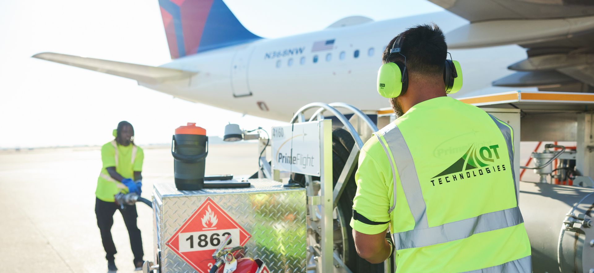 Aircraft technicians in safety vests performing maintenance on an airplane